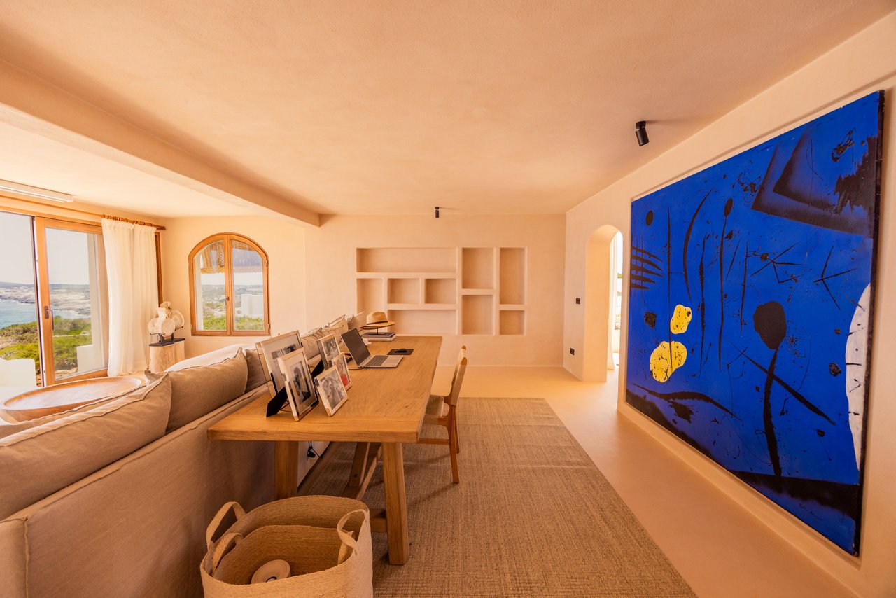 El salón con la mesa larga de madera y las ventanas en arco
