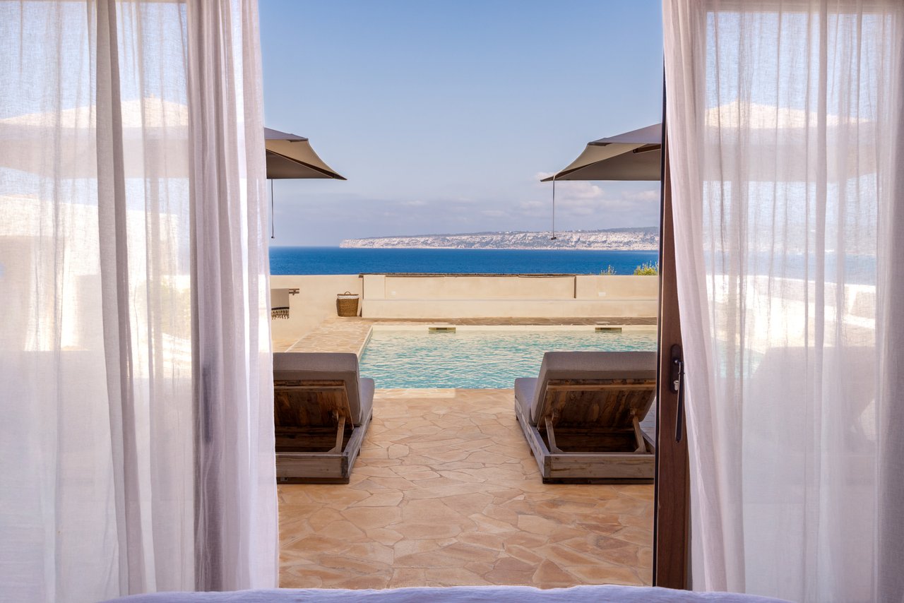 Vista desde la cama de la habitación 02 hacia la piscina y el mar