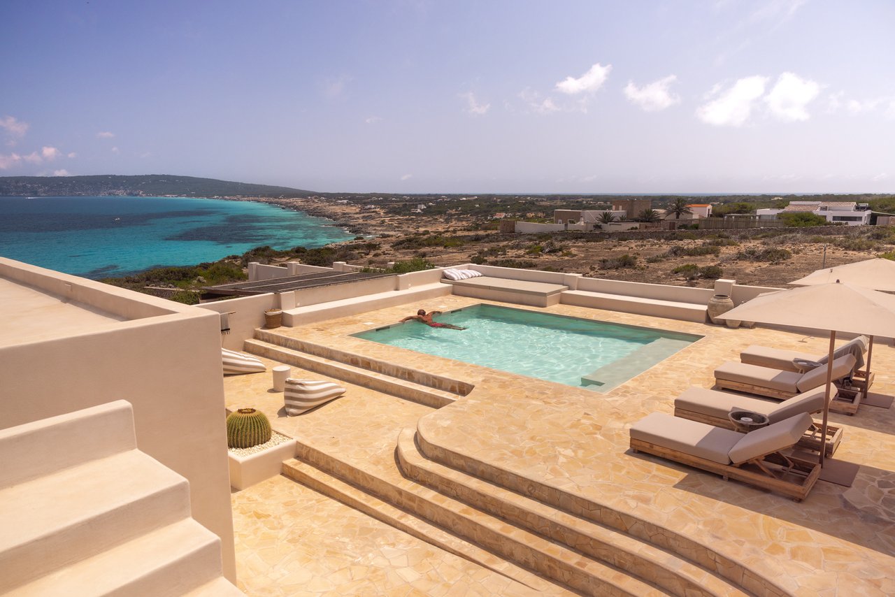 La piscina vista desde arriba, con los escalones de piedra y el mar turquesa